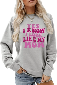 Detail of pink text slogan on a grey long sleeve sweatshirt for women in close-up