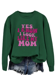 Detail view of a dark green crewneck sweatshirt with pink retro slogan print