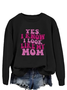 Detail of black crewneck sweatshirt with pink YES I KNOW I LOOK LIKE MY MOM print text