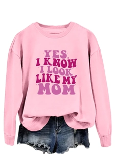 Detailed view of pink long sleeve sweatshirt with 'YES I KNOW I LOOK LIKE MY MOM' print