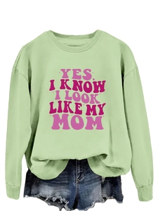 Detail of light green sweatshirt featuring pink Yes I Know I Look Like My Mom text print