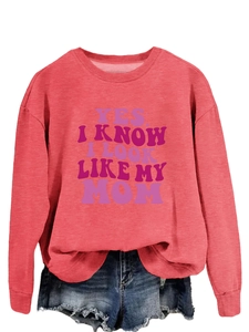 Detail of artistic lettering print on coral pink crewneck sweatshirt with denim shorts