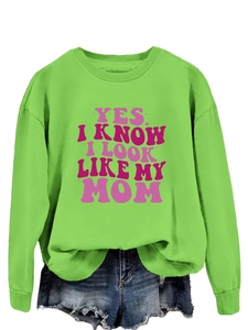 Detail of green crewneck sweatshirt with pink text YES I KNOW I LOOK LIKE MY MOM