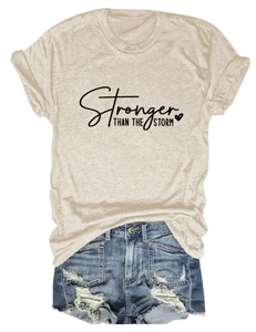Detail of Stronger Than The Storm text print on beige cotton t-shirt with heart icon