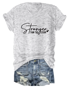 Detail of grey Stronger Than The Storm t-shirt paired with distressed denim shorts