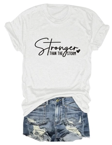 Close-up of Stronger Than The Storm text print on white cotton t-shirt fabric detail