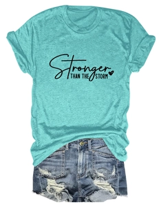 Detail of teal t-shirt with Stronger Than The Storm text and ripped denim shorts