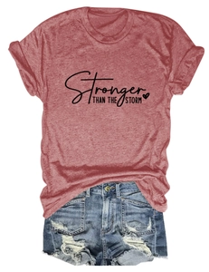 Detailed flat lay of red cotton t-shirt with Stronger Than The Storm slogan and denim shorts