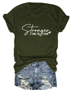 Flat lay of olive green cotton T-shirt with Stronger Than The Storm lettering print