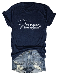 Flat lay of Stronger Than The Storm t-shirt and distressed blue denim shorts set