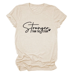 Close-up of Stronger Than The Storm print on oat beige cotton t-shirt with heart graphic