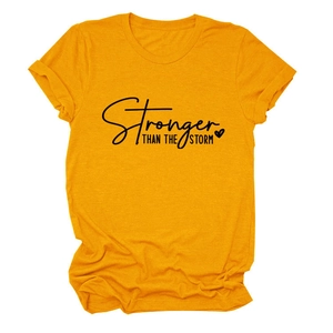 Detail of Stronger Than The Storm lettering on mustard yellow cotton t-shirt