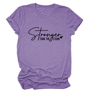 Close-up of Stronger Than The Storm text print on purple cotton t-shirt fabric