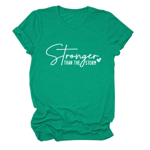 Close-up of Stronger than the Storm print on grass green cotton t-shirt fabric
