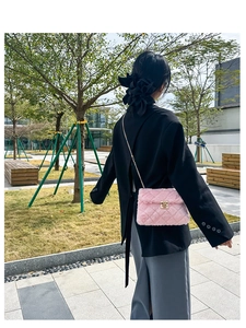 Detailed view of pink fuzzy crossbody bag featuring gold chain strap and quilted texture