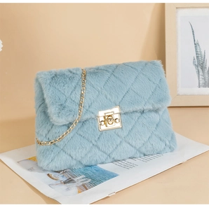 Detail of light blue faux fur crossbody bag with quilted pattern and gold chain strap