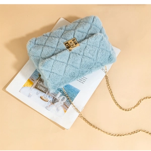 Detail of light blue faux fur quilted crossbody bag with golden twist lock on magazine