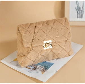 Close-up of camel plush square bag with quilted pattern and gold chain strap detail