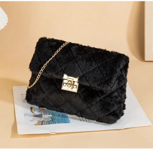 Detail view of plush quilted faux fur texture and golden metal lock on black chain bag
