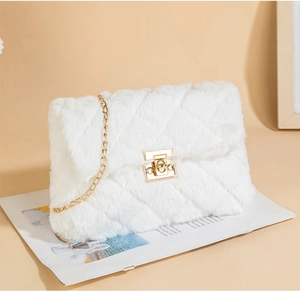 Detailed view of white faux fur square bag with diamond quilting and gold metal chain strap