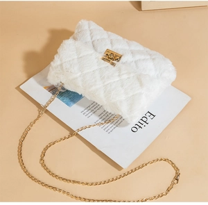 Detail view of quilted white faux fur bag with golden twist lock and chain strap
