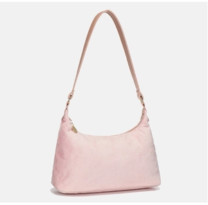 Detailed view of pink plush shoulder bag with golden hardware and beige strap
