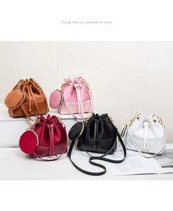 Close-up of bucket bag set featuring suede texture, gold chain handle and drawstring detail