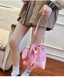 Pink suede bucket bag with matching round coin purse and gold chain strap detail