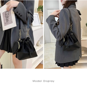 Detail view showing black bucket bag set with drawstring closure and chain shoulder strap