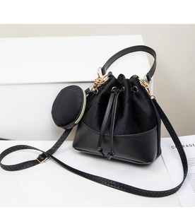 Detail of black velvet bucket bag with detachable coin purse and gold hardware accents