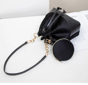 Detail view of black velvet bucket bag with leather base and matching round coin purse