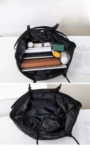 Detail view of spacious black tote bag interior showing multi-layer compartments and storage