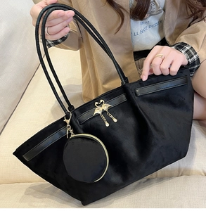 Detail of black velvet tote bag with golden swan ornament and detachable round coin purse