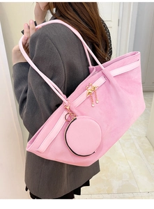 Pink suede tote bag and round coin purse set with flamingo charm shown on shoulder
