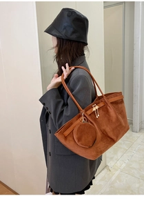 Brown suede tote bag shown with gold swan charm and detachable round coin purse