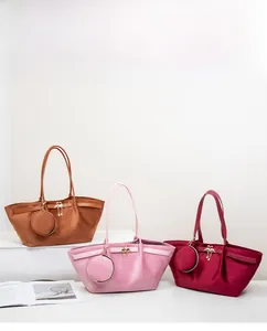 Detailed view of suede tote bags with golden swan charms and matching coin purses