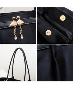Detail of black velvet tote bag featuring a swan tassel buckle and magnetic closure