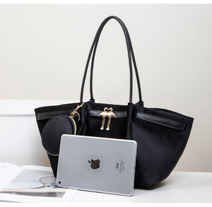 Detailed view of black velvet tote bag with gold swan buckle and matching round pendant
