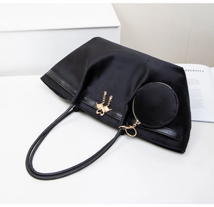 Detail of black velvet tote bag with gold swan charm and detachable round coin purse