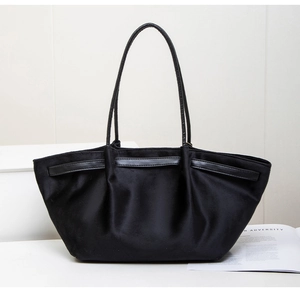 Detailed view of the black pleated tote bag fabric texture and long leather handles
