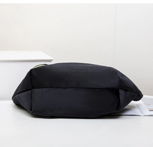 Detail of a black suede storage pouch with a premium gold zipper and structured bottom