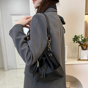 Ensemble sac seau femme en cuir noir et velours avec chaîne dorée porté par mannequin
