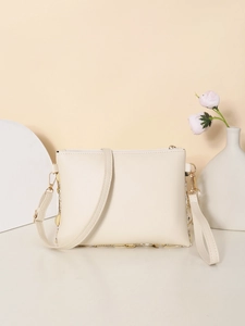 Detail showing the cream sequin crossbody bag with adjustable strap and floral background