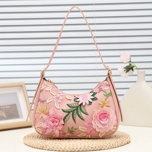 Borsa a spalla rosa con ricamo floreale e silhouette a mezzaluna su sfondo minimalista