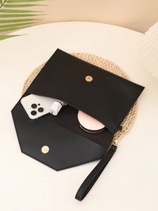 Detail showing internal storage of black envelope clutch with phone and cosmetics
