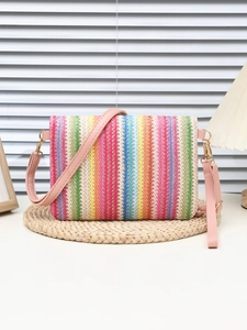 Detail of colorful striped woven shoulder bag with pink faux leather strap and gold hardware