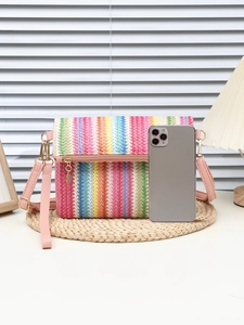 Close-up of colorful striped straw shoulder bag with pink leather strap and gold hardware