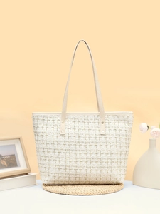 Gros plan du sac seau en tweed blanc avec fils dorés et bandoulière de couleur crème