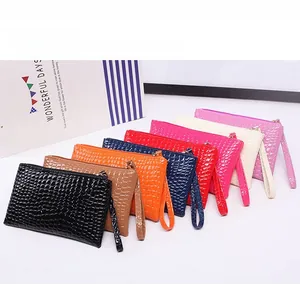 Macro display of eight colorful crocodile embossed mini wristlet pouches with zippers