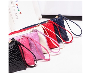 Detail view of multi-color crocodile pattern wristlet bags with metallic zippers and straps